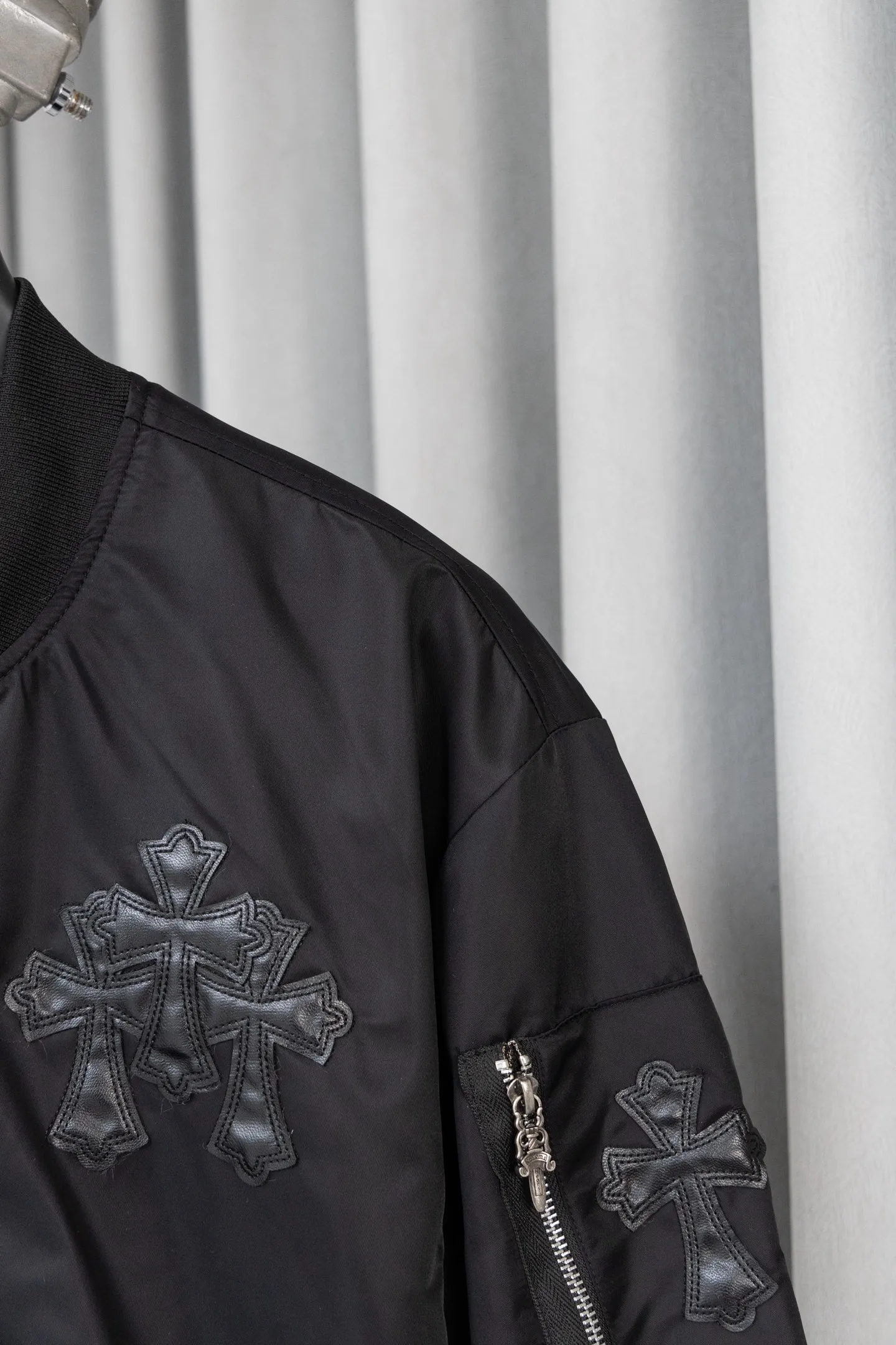 P410 Style No.: S045 This is a velvet baseball jacket from **Chrome Hearts**. It is a representative item of the brand that combines dark pioneer style with American street culture. It is also a trendy item that combines personality and warmth in autumn and winter. Design Highlights Iconic Elements: The brand’s classic cross leather embroidery is embellished throughout the body, paired with metallic hardware decorations (such as zipper pullers and hang tags). It combines Gothic religious symbols with heavy metal style, which is highly recognizable and is an intuitive embodiment of Crow Heart’s “dark luxury” tone.  Style and structure: It adopts the classic baseball uniform style, with a stand-up collar design and a two-way zipper, which is neat and stylish; the zipper pockets on the sleeves and the diagonal pockets on the body not only enhance the street feel, but are also practical.  Material splicing: The outer layer is made of high-density windproof fabric, and the inner layer is filled with velvet material, which has excellent thermal insulation performance; the threaded design of the collar and cuffs improves the overall crispness and wearing comfort. Craftsmanship and Quality: The cross is veneered using imported leather + hand-embroidered craftsmanship, with fine stitching and strong three-dimensional effect; the metal hardware has been distressed to give it a vintage and distressed texture, and the details reflect the brand's strict requirements for craftsmanship.  The velvet inner liner is evenly and fully filled, and the splicing process with the outer fabric is rigorous. It is not easy to deform after long-term wear, and has excellent warmth retention and durability. Style and Outfit This jacket is based on dark street style, and its black main tone is versatile and high-end. It can be paired with ripped jeans and Martin boots to create a cool street style in daily life; it can also be worn with a turtleneck sweater and a long coat on the outside. It can be layered to create layers, making it easily suitable for niche trendsetters, rock enthusiasts and other diverse style groups. It is an eye-catching item in the autumn and winter wardrobe that shows individuality. Size: s-XL Color: Black
